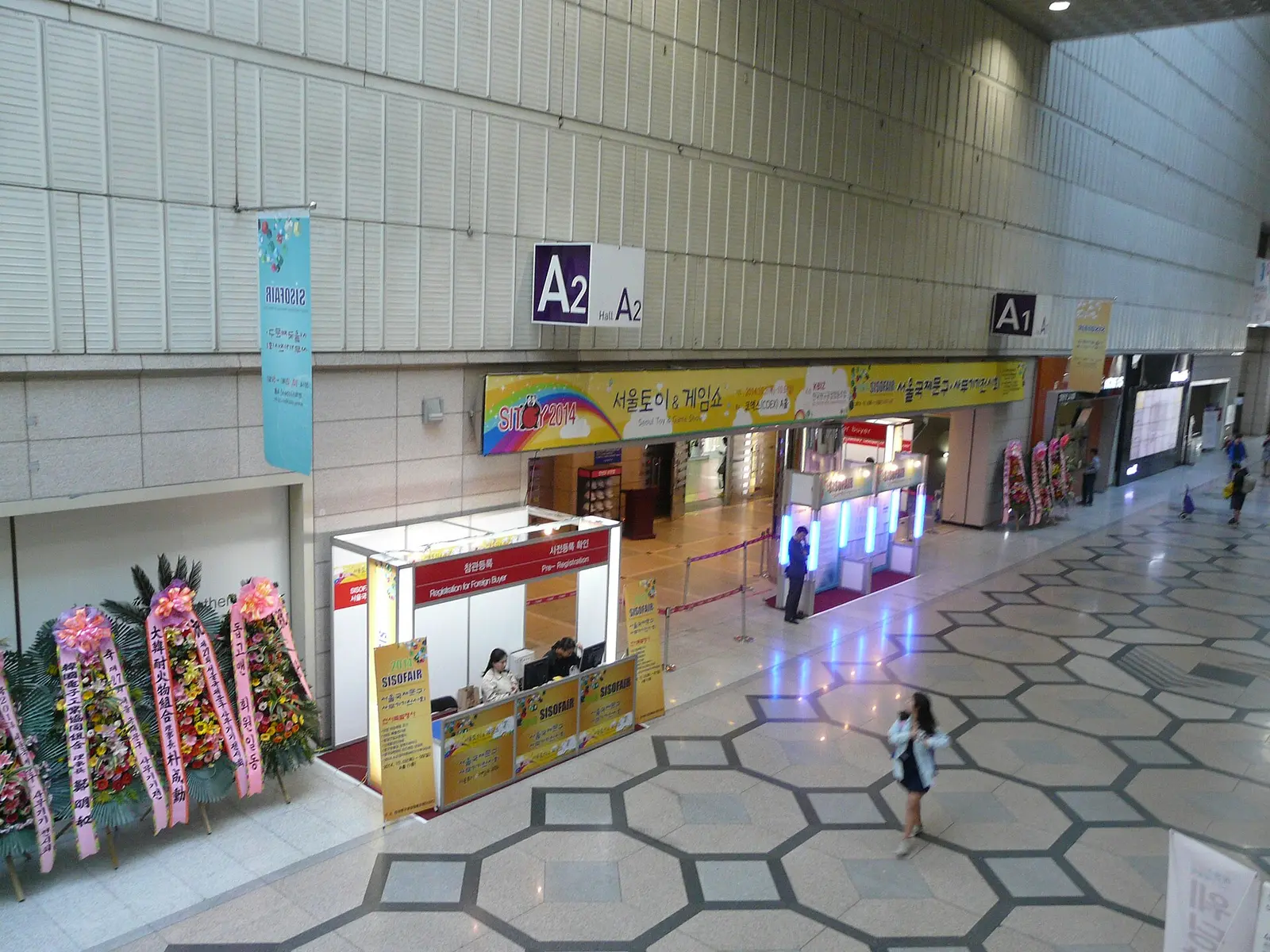 The hexagon-tiled concourse inside COEX Convention Center in Seoul with hall entrances and booths