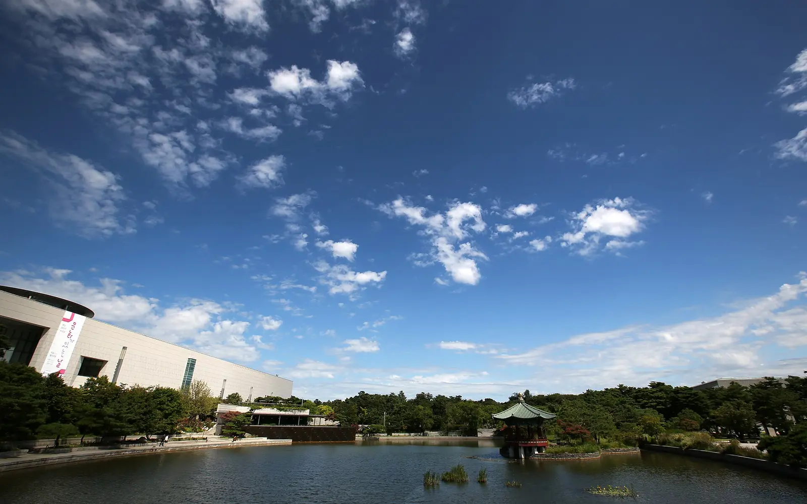 The pond and pavilion in the grounds of the National Museum of Korea in Seoul under a blue sky
