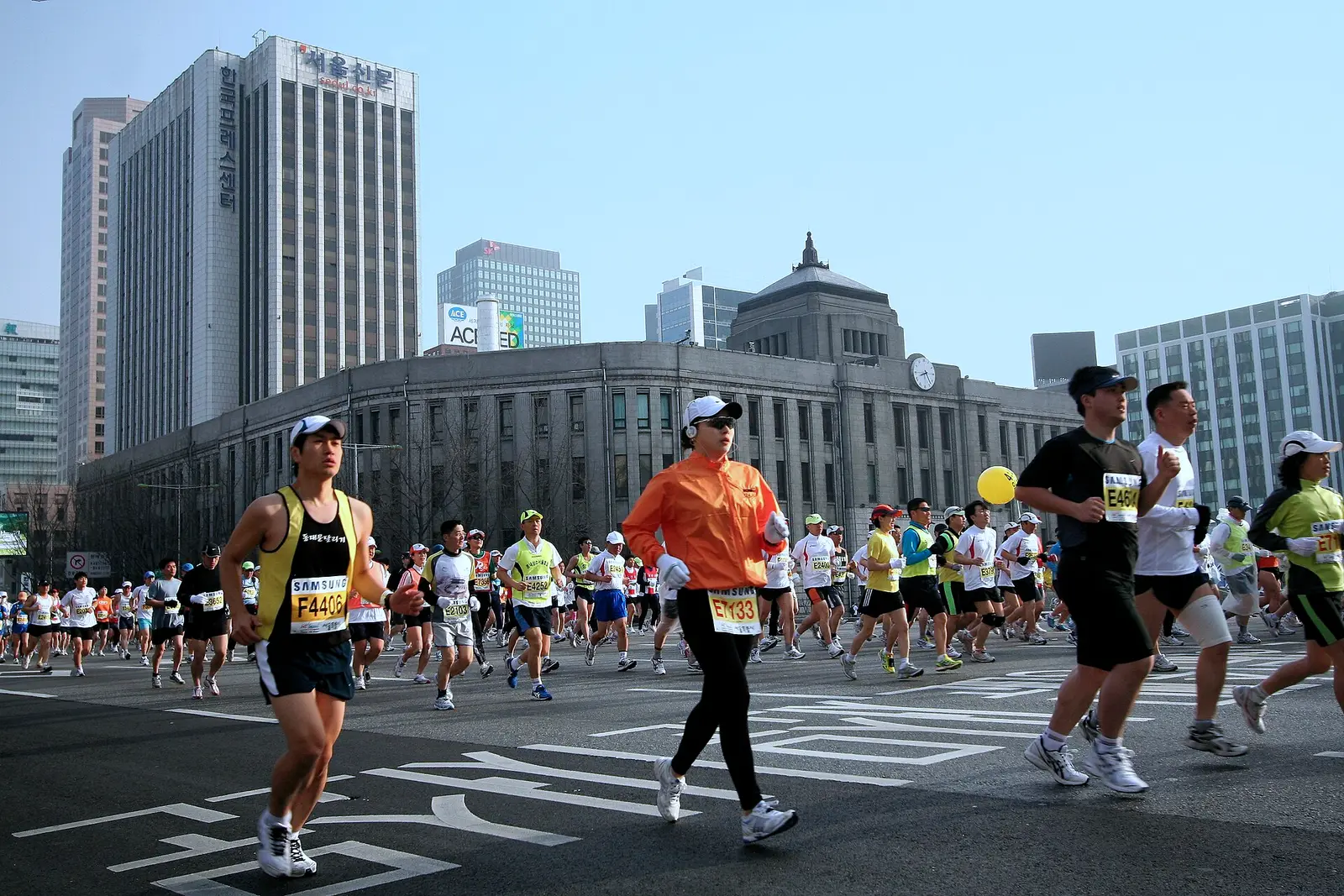 Runners in the Seoul International Marathon passing Seoul City Hall near the start of the course